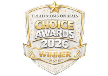 A gold and white shield badge reads Triad Moms on Main Choice Awards 2026 Winner with a star on top and laurel leaves at the bottom.