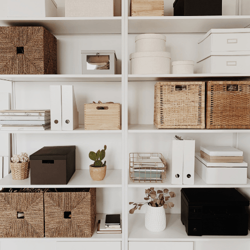organized shelf in living room with baskets